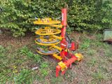 une machine rouge et jaune qui est garée dans l'herbe