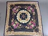 a close up of a black and gold scarf with roses on it