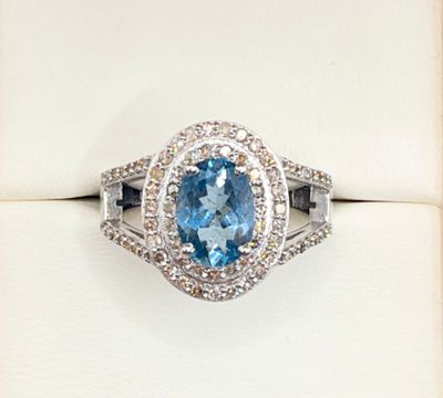 an image of a ring with a blue topaz stone surrounded by diamonds