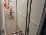un long couloir avec un miroir et un porte-vêtements à l'intérieur