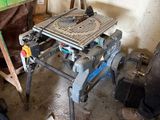 une table sur laquelle se trouve une scie, dans une pièce