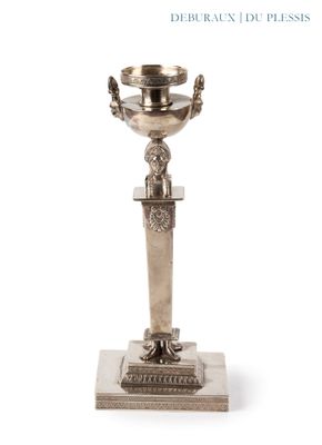 une coupe en argent posée sur un socle, sur fond blanc