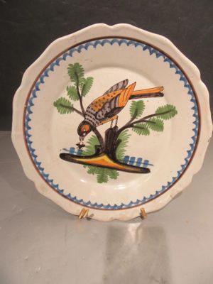a plate with a bird painted on it on a table