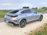 the rear end of a silver mercedes suv parked on a dirt road