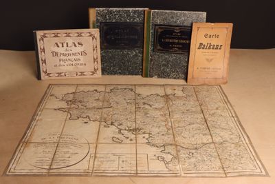 trois livres posés sur une table sur laquelle se trouve une carte