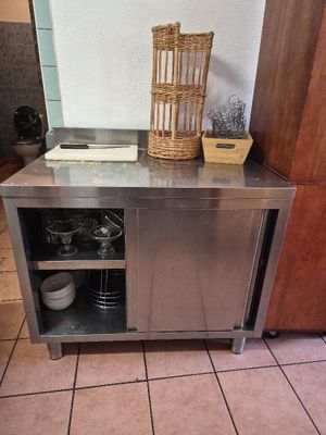a kitchen with a stainless steel counter and a basket on top of it