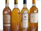 several bottles of wine are lined up on a white surface