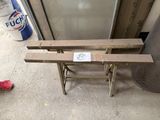 a wooden bench with a sticker on it next to a trash can