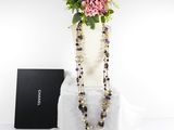 purple and black beaded necklace with flowers in a white vase