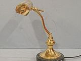 a gold lamp that is on a marble base