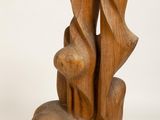 a wooden sculpture that is sitting on a white surface