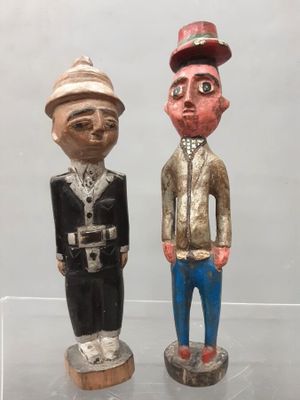 two wooden figurines of men standing next to each other