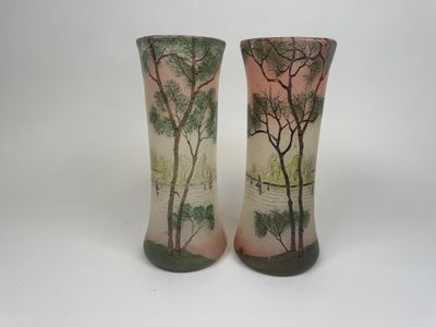 deux vases décorés d'arbres, posés sur une table