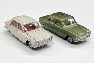 deux voitures jouets assises l'une à côté de l'autre sur une surface blanche