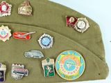 a lot of pins and badges on a green hat