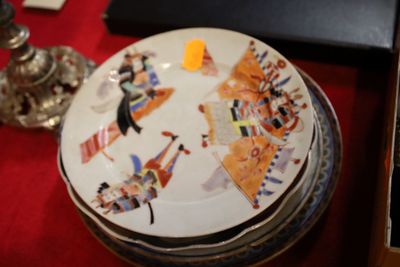 une pile d'assiettes posée sur une table recouverte d'une nappe rouge