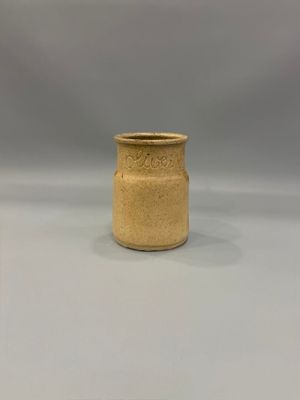 vase en céramique beige, avec un bord doré sur fond blanc