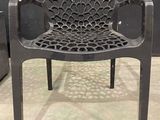 a black plastic chair with a spider web design on it
