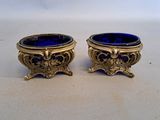 une paire de vases en verre bleu rehaussés de touches dorées, posés sur une table