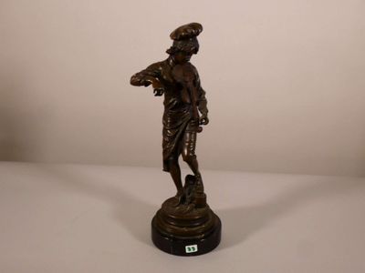 statue en bronze représentant une femme tenant un panier de fleurs posé sur une table