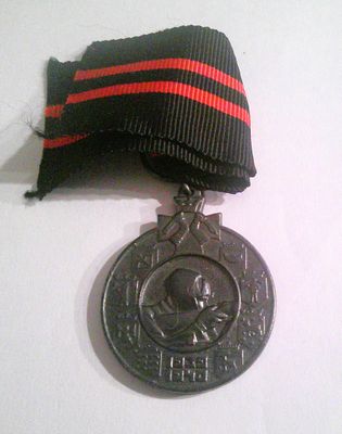 a silver medal with a red and black ribbon on it