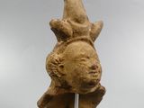 an image of a statue of a bird on top of a wooden stick