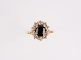 une bague en or sertie d'une pierre noire entourée de diamants blancs