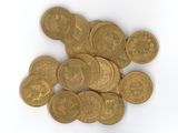 une pile de pièces d'or posée sur une surface blanche