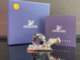 une figurine en cristal posée sur une table, à côté d'une boîte bleue