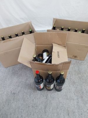 plusieurs bouteilles de vin dans un carton posé par terre