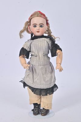a small doll that is standing on a white surface