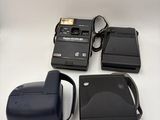 an image of a camera and other electronics on a white surface