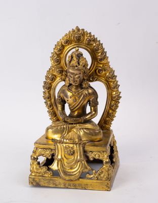 a gold statue of a buddha sitting on a table