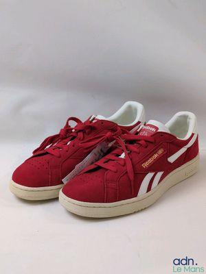 une paire de baskets rouges avec des lacets blancs