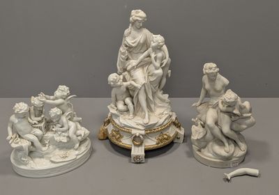 trois statues blanches représentant des personnages et des animaux, posées sur une table