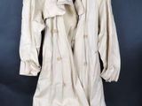 une photo d'un trench-coat blanc suspendu à un cintre