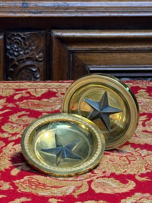 une assiette en or ornée d'une étoile, posée sur une table rouge