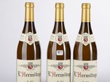 trois bouteilles de vin posées sur une table blanche