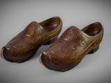 pair of old wooden clogs on a gray surface