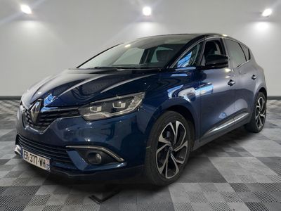 la voiture bleue est garée sur le sol en damier d'un garage