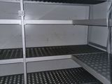 many shelves that are in the corner of a room