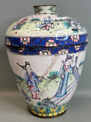 un vase avec un tableau posé sur une table