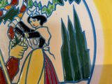 a yellow plate with a picture of a woman and a bird on it