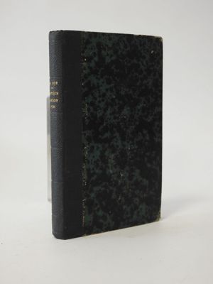 an old book sitting on top of a table on a white surface