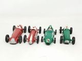 four toy cars lined up in a row on a white surface