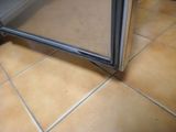 a glass door that is open on a tiled floor