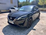 a black nissan qx parked in a parking lot next to a building