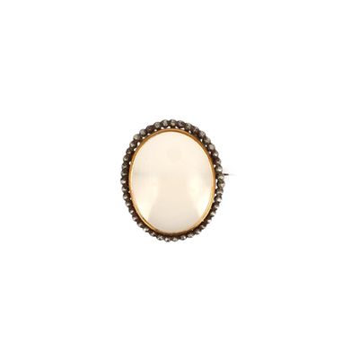 un gros plan d'une bague en pierre blanche sur fond blanc