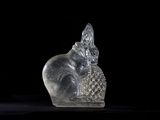 a glass figurine of a cat sitting on a table