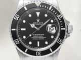 une montre Rolex à cadran noir montée sur un bracelet